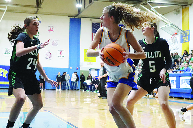 Lowry's Matti DeLong fends off Churchill County defenders Kortnie Simper (24) and Brynlee Nichols (5) during Friday's game in Winnemucca.