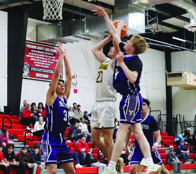 Battle Mountain’s Chase Lutz splits two Yerington defenders on his way to the basket during the opening round of the Northern 2A Regional Championships in Lovelock.