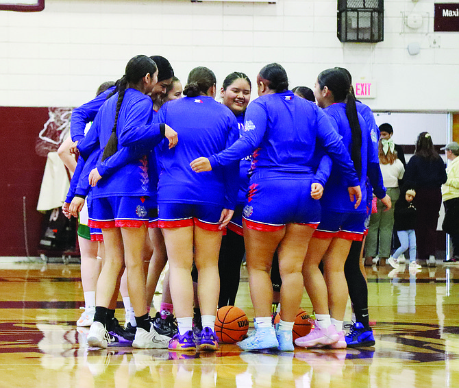 The McDermitt High School girls basketball team gathers at center court prior to its regional championship game with Eureka at Elko High School on Saturday, Feb. 15.