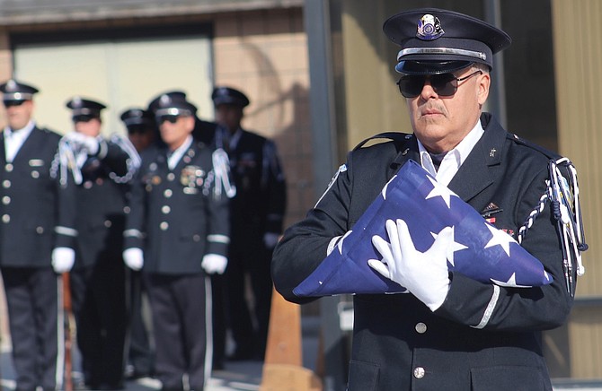 Chaplain Fred Wilson carries the U.S. flag at Thursday’s unaccompanied service at the Northern Nevada Veterans Memorial Cemetery in Fernley.