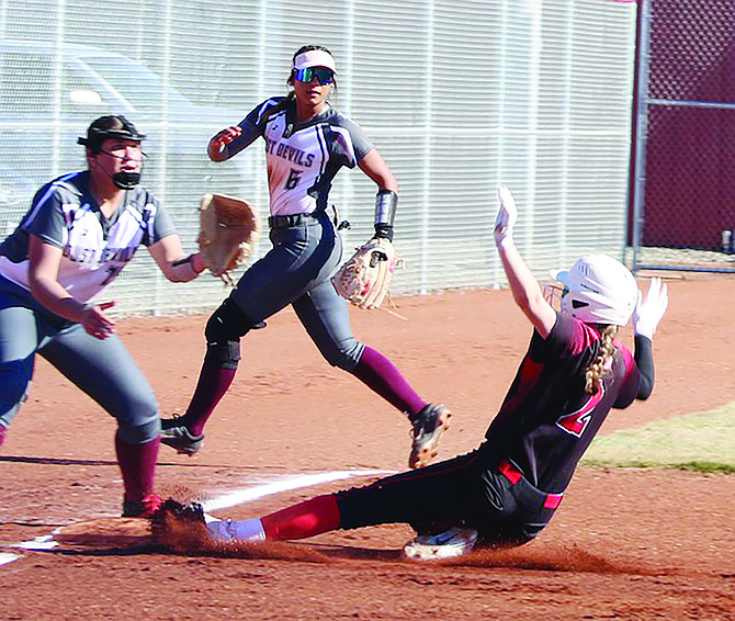 Pershing County’s Kyra Cerini slides into third base against the Dust Devils.