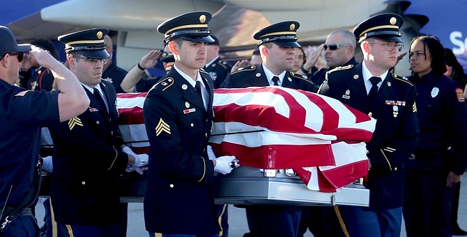 Members of the Nevada Army National Guard carry a casket with the remains of World War II soldier Roman Cherubini to a waiting hearse on Friday.