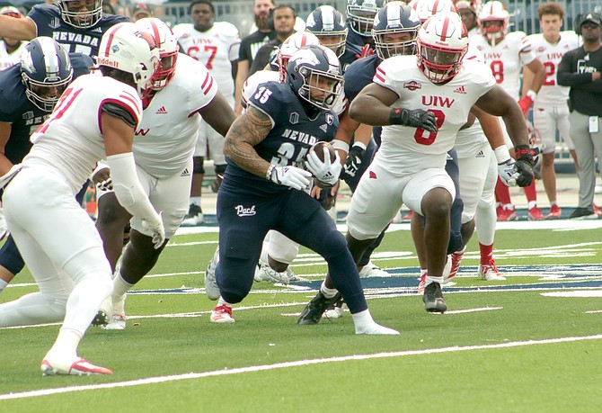 Nevada running back Toa Taua breaks through the line in a 2022 game at Mackay Stadium. Taua led the Wolf Pack in rushing yardage for five straight seasons but never cracked the 1,000-yard barrier.