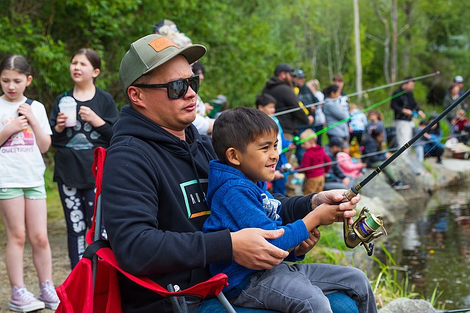 Nathan holds his nephew Nova as Nova has a reel out into Jennings Park Pond of Marysville on Saturday, May 3 during the Everett Steelhead and Salmon Youth Organization’s first of three youth fishing days.