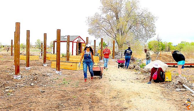 Main Street Director Jen Tune tows a wheelbarrow at the Heritage Park Gardens on May 3. Work is progressing on the gardens' renovation.
