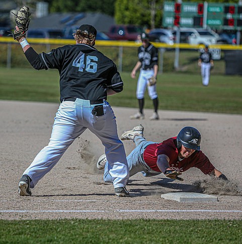 Jackson first base senior Sam Craig stretches for the throw as a Cascade base runner dives for the bag in early inning action May 5. Cascade managed to eke out a 8-7 win over Jackson on Jackson High’s diamond. In the early innings, the Jackson pitcher filled the bags twice and walked in 2 runs, and hit a batter with a ball. The game was played on a perfect spring afternoon.