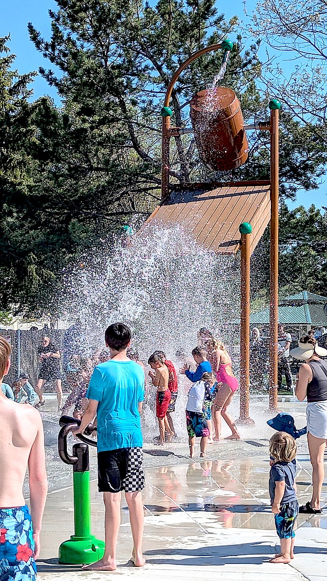 Water dumps over kids from a suspended bucket at the new splash pad at Westwood Park on Ironwood Drive in Minden.