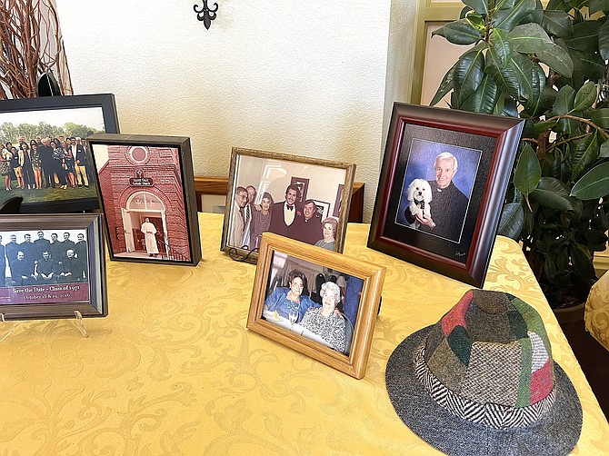 A display table with Father John Corona's hat and photos from his life.