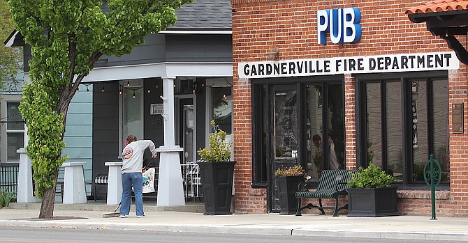 A man sweeps the sidewalk in front of the Overland in Gardnerville on May 3.