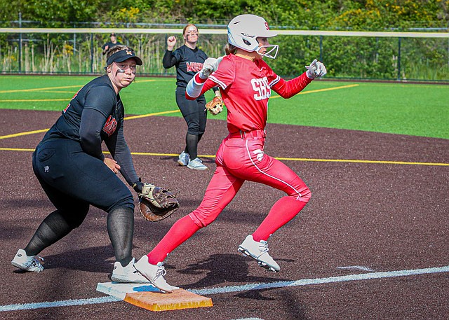 3A Districts: Monroe Bearcat first base junior Vivian Knuckey watches the missed throw to first as Stanwood Spartan senior, Reagan Ryan blitzes past during the Districts match up May 13 at the Phil Johnson Ballfields in Everett.
Stanwood won 8-1, with the blistering pitching of sophomore Addi Anderson powering the Spartans to the win.  Anderson threw 10 strikeouts, giving 3 hits and one run for a complete game in the circle. The Spartans smothered the Bearcats with doubles and singles throughout the contest.