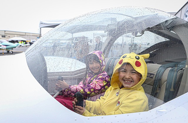 Leo Bailey, 7 , in yellow, and his friend Sasha, 8, both of Mukilteo, try out the “stick and rudder” of a small Boeing Flight Club two seater during the Paine Field Community Day Saturday, May 17. Hundreds of families came in the rain to see the planes at the county-owned airport between Everett and Mukilteo. The event included displays of new and old aircraft, and the ability to poke inside some such as a sheriff’s office helicopter.