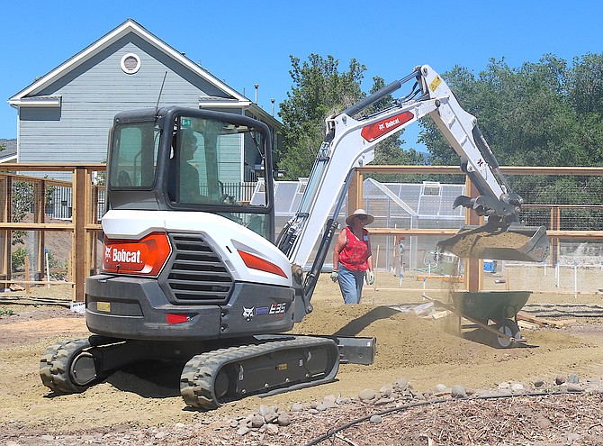Filling the beds at Main Street Gardens was wheelbarrow work on Saturday.