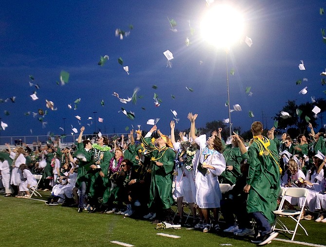 Graduates throw their caps in the air after graduation.