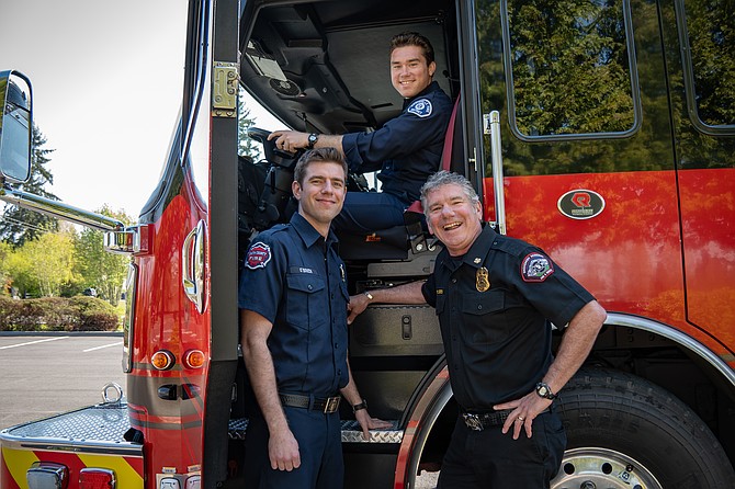 Snohomish Regional Fire and Rescue Chief Kevin O’Brien with his sons Keenan (sitting in fire engine), a firefighter at Marysville Fire, and Daniel (standing) a firefighter with South County Fire.