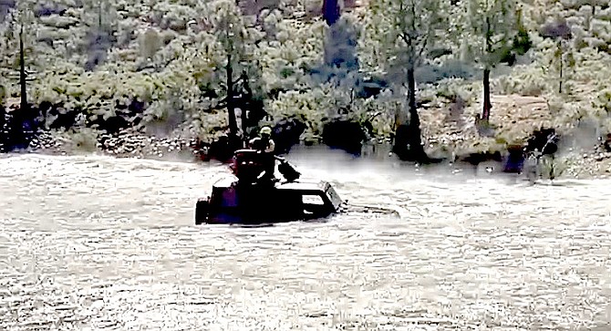 The occupant of a Jeep that became stuck in the East Fork of the Carson River below Markleeville is picked up by a California Highway Patrol helicopter on Monday.
