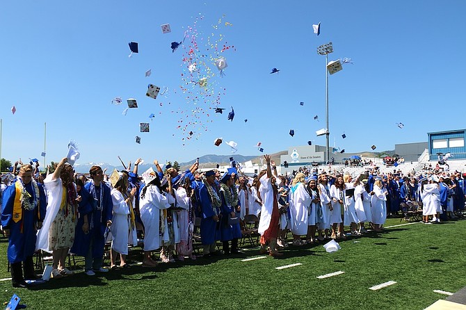 Carson High School’s Class of 2025 graduates toss their caps in the air Saturday on the football field.