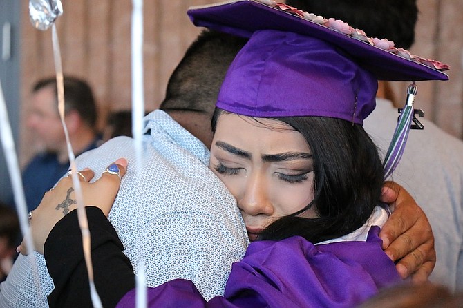 Pioneer graduate Joanna Martinez-Hernandez hugs a loved one after crossing the stage.