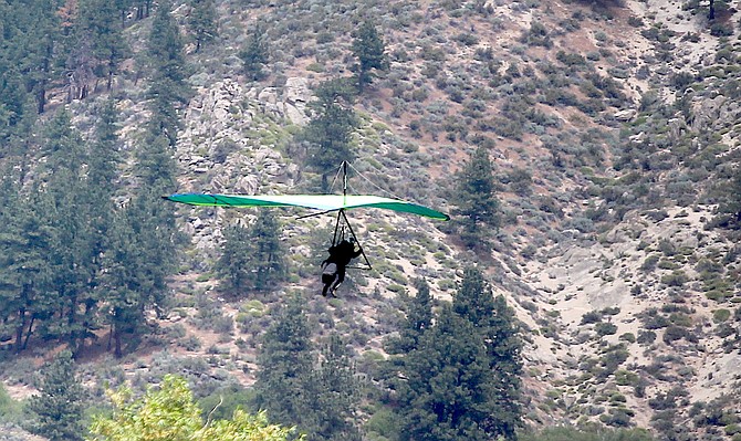 A hanglider comes in for a landing just off Jacks Valley Road on Sunday afternoon.