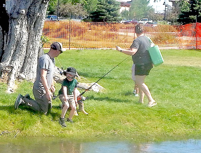 A tyke calls his shot by pointing at a fish at the Kids Fishing Derby.