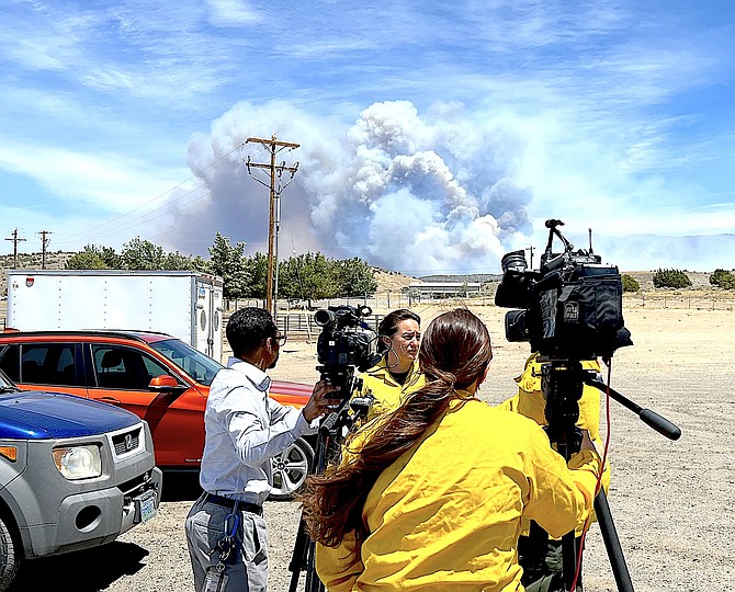 Fire spokeswoman Jenn Diamond speaks with reporters as the Conner Fire burns in the background on Friday afternoon.