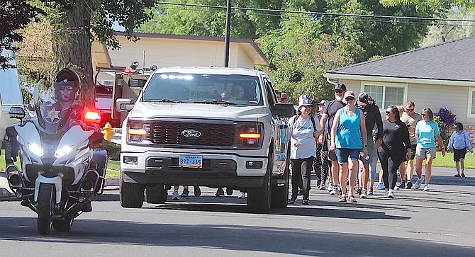 Members of the Kiwanis Aktion Club walk down Wildrose on Monday morning with an escort by the Douglas County Sheriff's Office. Sheriff Dan Coverley and District Judge Tod Young participated in the walk.