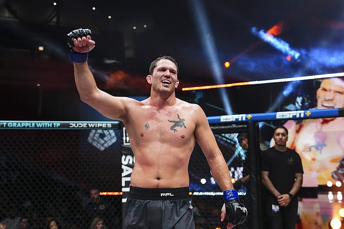 Sullivan Cauley raises his hand Friday after defeating Phil Davis in the PFL World Tournament light heavyweight semifinals. Cauley will fight in the finals later this year.