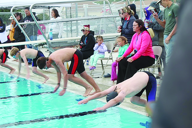 Racers launch from the edge as younger fans and family members cheer them on at the Lovelock Classic swim meet.