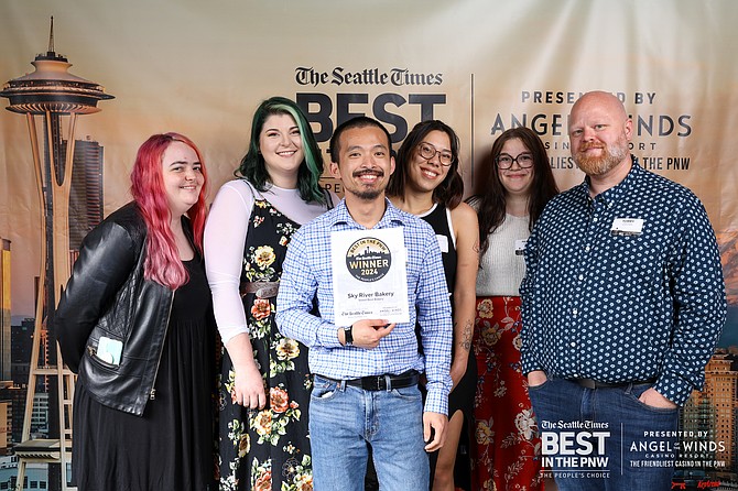 The team at Sky River Bakery, including cake decorator Alicia (second to left) and owner and baker Rick Leng (center, holding award), pose for a photo to celebrate being a Seattle Times Best of the PNW winner.