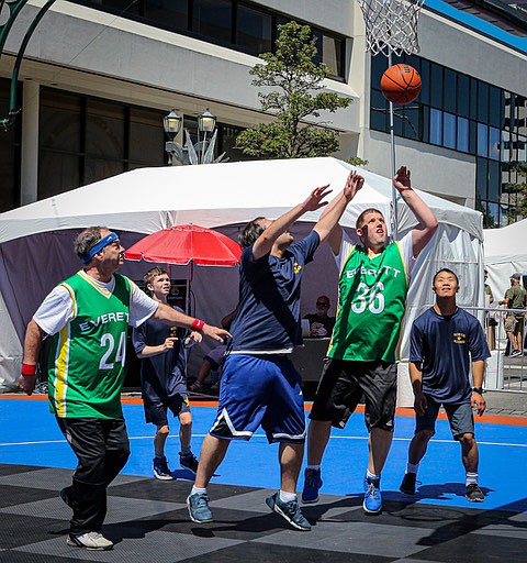 In the Special Olympics final matchup of the amateur Boeing 
3-on-3 Basketball Tournament, played July 12 on the hot streets of downtown Everett, the North Sound Kraken, in purple, go up against the Everett Huskies in green.  The Kraken included Cameron H., Jian H., and Osmer M.,while the Huskies fielded David P., Dean S., and Jason W.  The final one was Huskies 12, Kraken 9.  The dominant Huskies took the two opening matches 13 - 7 and 9 -4 .