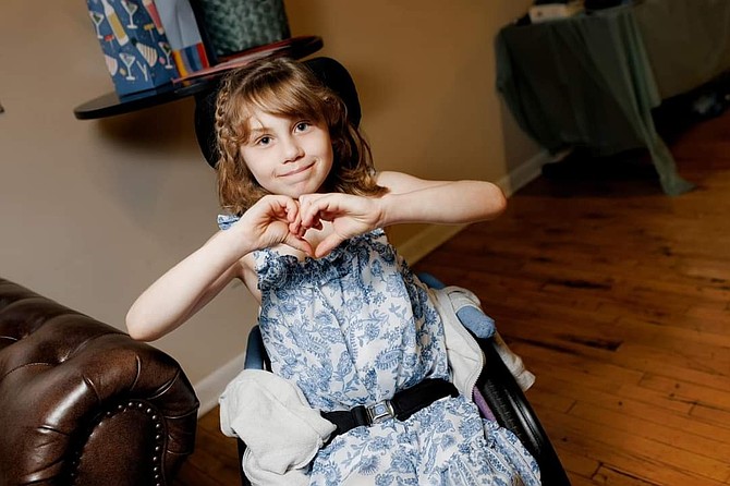 Katja De Groot, 9, poses with her hands in a heart position. As of July 4, she awaited a partial heart transplant to be done by the doctors at Duke University’s medical center.