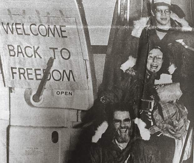 RHEIN-MAIN AIR BASE, W. Germany: Freed American hostages Duane Gillette (top), Kathryn Koob and an unidentified man greet the crowd at Rhein-Main Air Base on their arrival Wednesday morning from Algiers en route from Tehran.