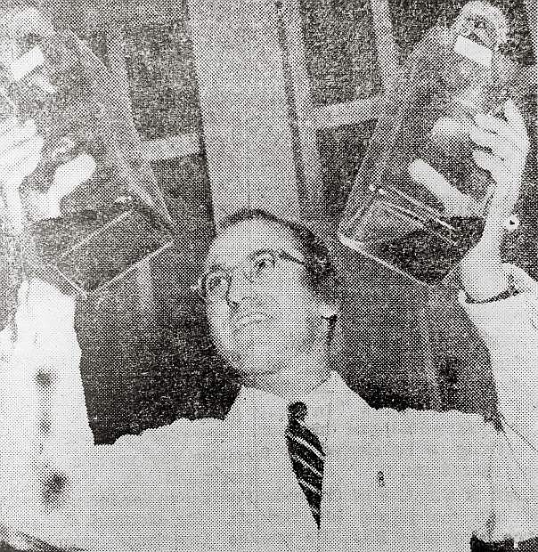 TRIUMPHANTLY HOLDING two bottles of vaccine, Dr. Jonas E. Salk has moment of glory at Ann Arbor, Mich., as he learns his remedy is 80 to 90 percent effective in war on polio.