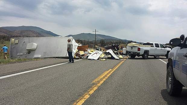 What appears to be a travel trailer is strewn over the highway on Sunday after a three-vehicle collision on Sunday.