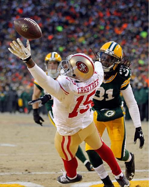 San Francisco 49ers wide receiver Michael Crabtree (15) misses a pass reception against Green Bay Packers cornerback Davon House (31) during the first half of an NFL wild-card playoff football game, Sunday, Jan. 5, 2014, in Green Bay, Wis. (AP Photo/Mike Roemer)