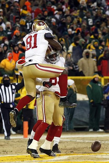 San Francisco 49ers wide receiver Anquan Boldin (81) jumps on tight end Vernon Davis (85) after Davis makes a touchdown catch during the second half of an NFL wild-card playoff football game against the Green Bay Packers, Sunday, Jan. 5, 2014, in Green Bay, Wis. (AP Photo/Jeffrey Phelps)