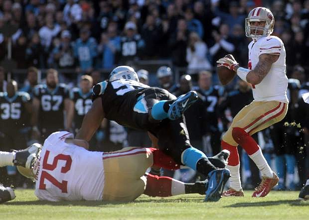 San Francisco 49ers Colin Kaepernick, right, looks to pass during a divisional playoff NFL football game against the Carolina Panthers, Sunday, Jan. 12, 2014, in Charlotte, N.C. (AP Photo/The Star, Ben Earp)