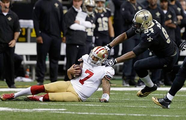 San Francisco 49ers quarterback Colin Kaepernick (7) slides as he is stopped by New Orleans Saints defensive end Cameron Jordan (94) in the first half of an NFL football game in New Orleans, Sunday, Nov. 17, 2013. (AP Photo/Dave Martin)