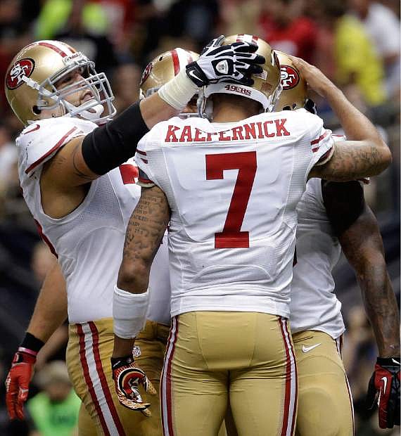 San Francisco 49ers quarterback Colin Kaepernick (7) celebrates his touchdown pass in the second half of an NFL football game against the New Orleans Saints in New Orleans, Sunday, Nov. 17, 2013. (AP Photo/Dave Martin)