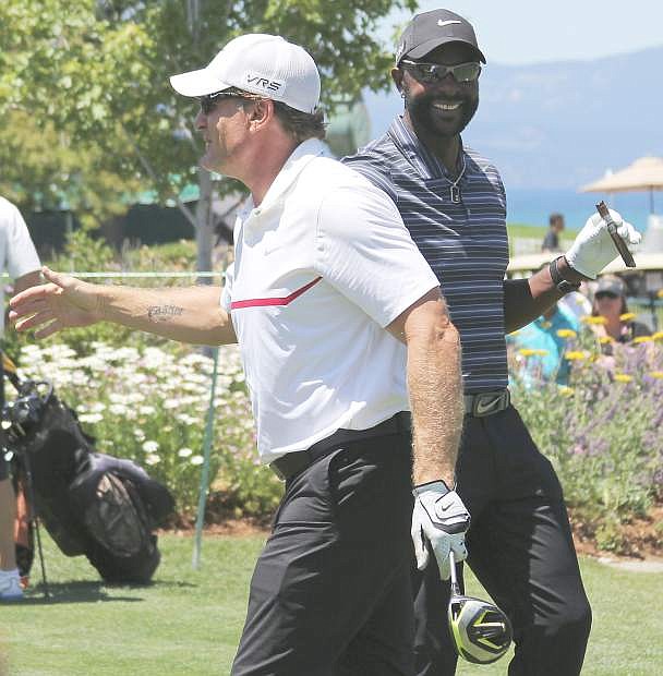 Jeremy Roenick (left) and Jerry Rice (right) exchange pleasantries at the first tee box before starting their practice rounds Wednesday at Edgewood.