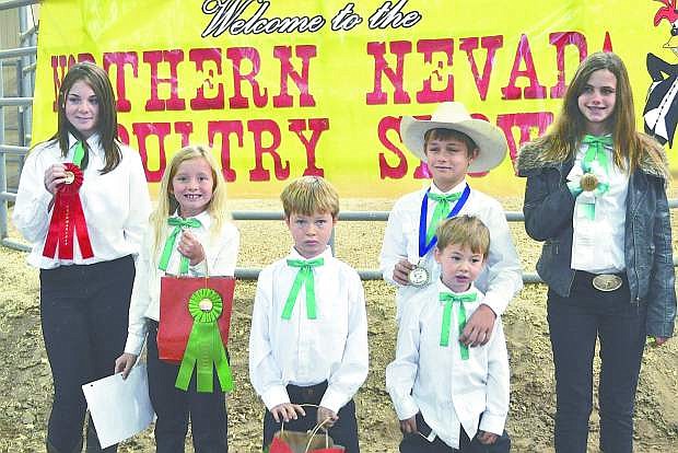 the Churchill County 4-H Hot Wings Poultry Club competed at the Northern Nevada Poultry Fanciers Association&#039;s Youth and Open Poultry Show, held at the Hutchings Ranch in Fallon.  From left to right, Catherine Burns won second place in Novice Showmanship. Nicole Nelson participated in PeeWee Showmanship, and her birds each brought home ribbons. Bob Behimer showed in Peewee showmanship and his 5 birds won many ribbons. Ethan Behimer (front) had a hen win Reserve Champion English of the open and youth show.  Nick Behimer won first in Novice Showmanship and his 5 birds did very well.  Julia Wideman won third place in Intermediate Showmanship and her hen won Reverse Champion in the Other Standard Breeds Class in the quality competition.