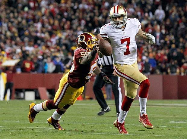 San Francisco 49ers quarterback Colin Kaepernick runs out of the reach of Washington Redskins inside linebacker Perry Riley during the first half of an NFL football game in Landover, Md., Monday, Nov. 25, 2013. (AP Photo/Alex Brandon)