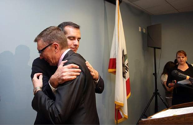 Los Angeles Mayor Eric Garcetti, right, embraces Los Angeles Schools Superintendent John Deasy John Deasy at news conference Friday, April 11, 2014, in Los Angeles, concerning the bus crash that claimed the lives of 10 students in Northern California. (AP Photo/Nick Ut)