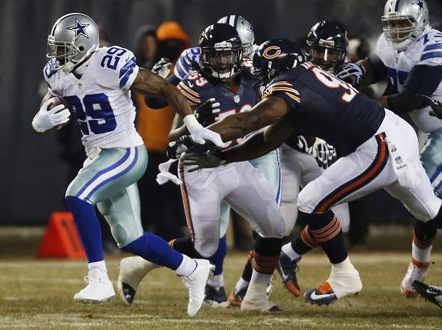 Dallas Cowboys running back DeMarco Murray (29) rushes past Chicago Bears defenders during the first half of an NFL football game, Monday, Dec. 9, 2013, in Chicago. (AP Photo/Charles Rex Arbogast)