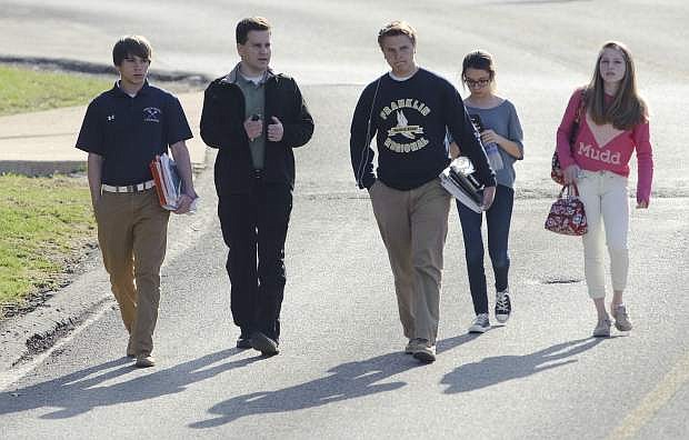 Students and a guardian walk to their car from Franklin Regional Middle School after more then a dozen students were stabbed by a knife wielding suspect at nearby Franklin Regional High School on Wednesday, April 9, 2014, in Murrysville, Pa., near Pittsburgh. The suspect, a male student, was taken into custody and is being questioned. (AP Photo/Tribune Review, Brian F. Henry)  PITTSBURGH OUT