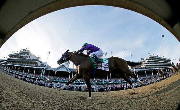 In this image taken with a fisheye lens, jockey Victor Espinoza rides California Chrome to win the 140th running of the Kentucky Derby horse race at Churchill Downs Saturday, May 3, 2014, in Louisville, Ky. (AP Photo/Matt Slocum)