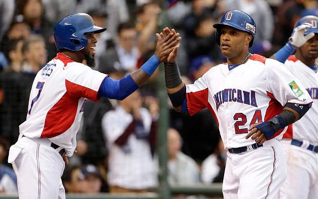 The Dominican Republic&#039;s Jose Reyes, left, and Robinson Cano celebrate after scoring against Puerto Rico during the first inning of the championship game of the World Baseball Classic in San Francisco, Tuesday, March 19, 2013. (AP Photo/Eric Risberg)