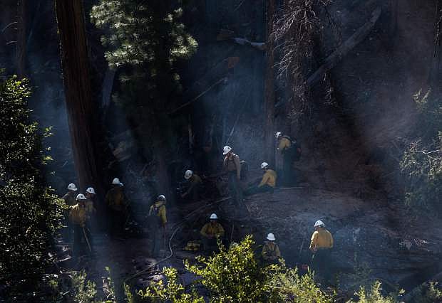 Firefighters take a moment to rest before continuing to contain the burn areas of a wildfire off U.S. Route 50, Saturday, July 25, 2015, in El Dorado National Forest. The blaze broke out Thursday near South Lake Tahoe and has charred more than 200 acres in heavy timber along steep canyon walls. (Andrew Seng/The Sacramento Bee via AP) MANDATORY CREDIT