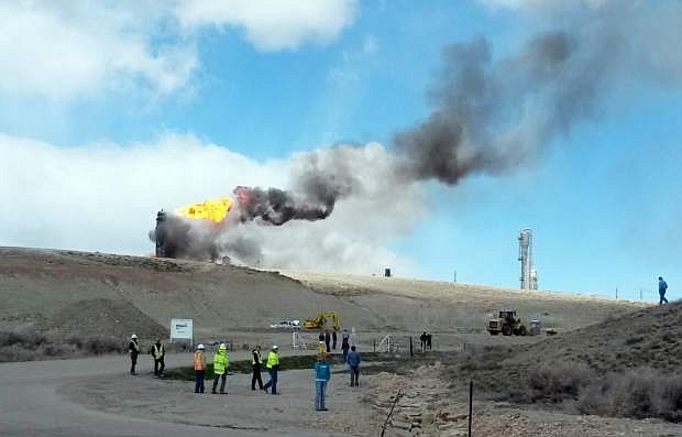 This image provided by Rachel Anderson shows officials at the site of an explosion and fire at a natural gas processing facility and major national pipeline hub, Wednesday, April 23, 2014, in Opal, Wyo. Officials said there are no reports of injuries and the residents of Opal have been evacuated to an area about 3 miles outside the town as a precaution. Opal has about 95 residents and is about 100 miles northeast of Salt Lake City. (AP Photo/Rachel Anderson)