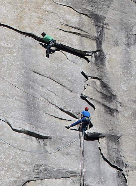 Kevin Jorgeson of California, wearing green, and 36-year-old Tommy Caldwell, wearing blue, near the summit of El Capitan Wednesday, Jan. 14, 2015, as seen from the valley floor in Yosemite National Park, Calif. The two climbers vying to become the first in the world to use only their hands and feet to scale a sheer granite face in California&#039;s Yosemite National Park are almost to the top. Jorgeson and Caldwell have been attempting what many thought impossible. The men have been &quot;free-climbing&quot; to the 3,000-foot summit for 17 days, meaning they don&#039;t use climbing aids other than ropes only to prevent deadly falls. Each trained for more than five years, and they have battled bloodied fingers and unseasonably warm weather. (AP Photo/Ben Margot)