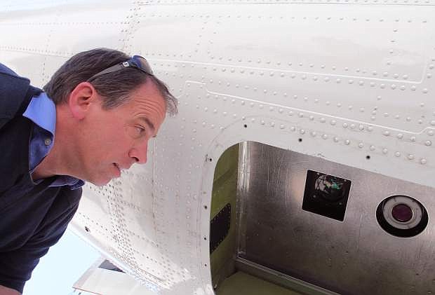 Tom Painter, principal investigator on an aerial snow survey program for NASA and the California Department of Water Resources, looks at instruments on the bottom of a plane used to conduct the surveys at Lake Tahoe Airport Friday morning. Adam Jensen / Tahoe Daily Tribune.